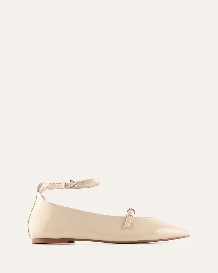 Beige flat shoe with ankle strap on a light gray background