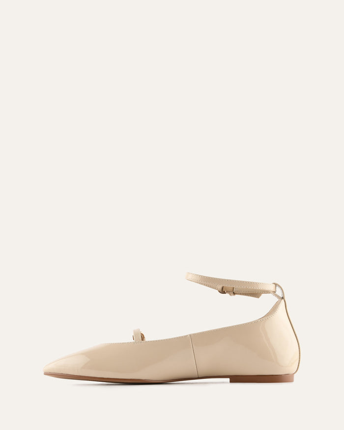 Beige flat shoe with ankle strap on a white background