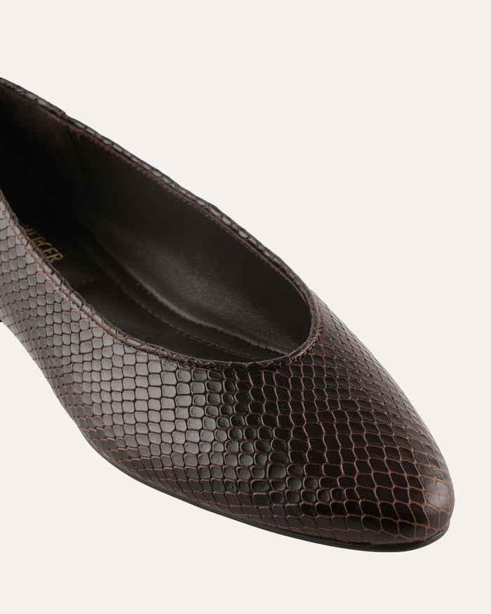 Brown pointed-toe shoe with snake skin pattern on a white background