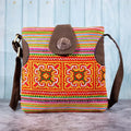 Vindigo orange hemp crossbody bag front view with H’mong embroidery and coconut button