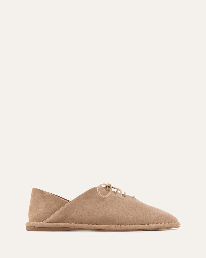 Beige flat shoe on a white background