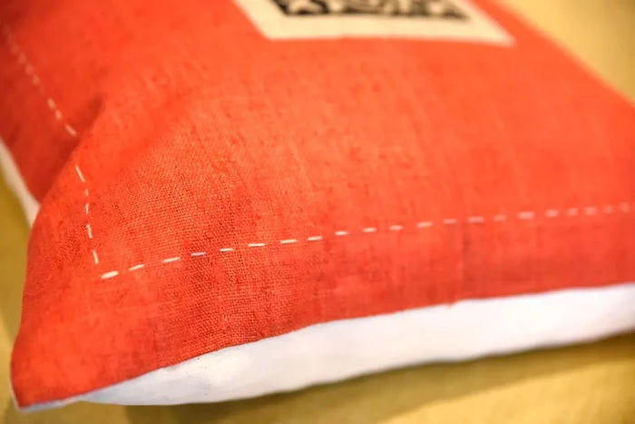 Närbild som visar handsydda sömmar på orange hampatyg