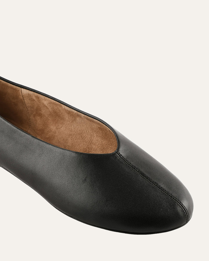 Black leather flat shoe on a white background