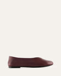 Maroon flat shoe on a light beige background