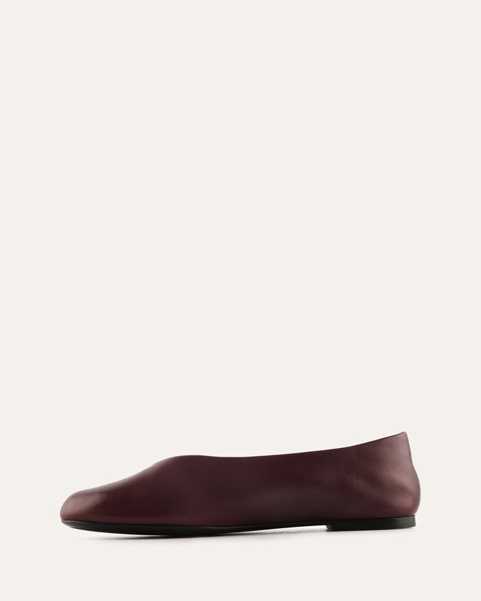 Maroon flat shoe on a light gray background