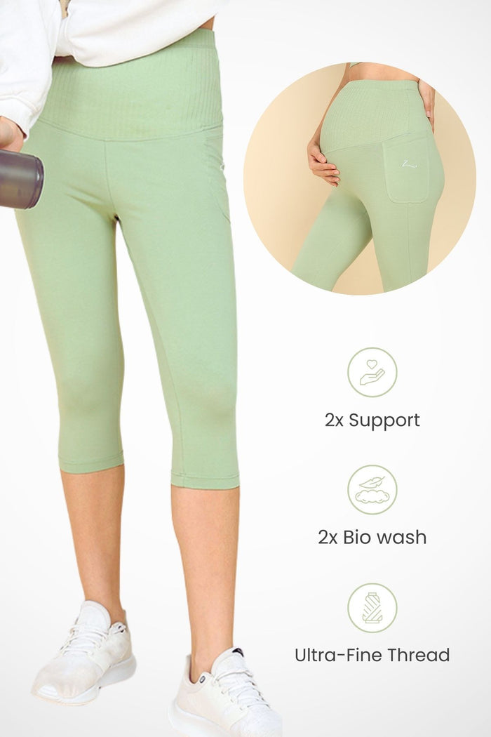 Model wearing Pistachio Capri; wide ribbed cotton panel stretches comfortably over the pregnant bump.