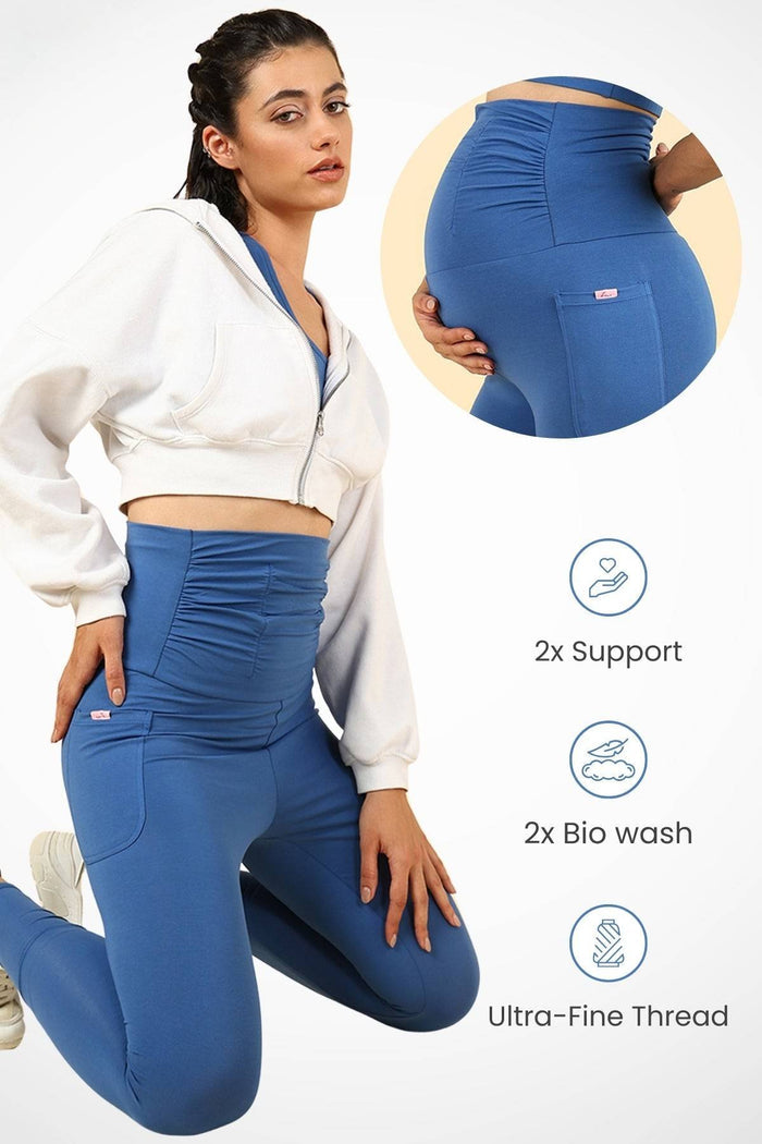 Model wearing Blue Ruched Legging; ruched maternity panel stretches over the pregnant bump.