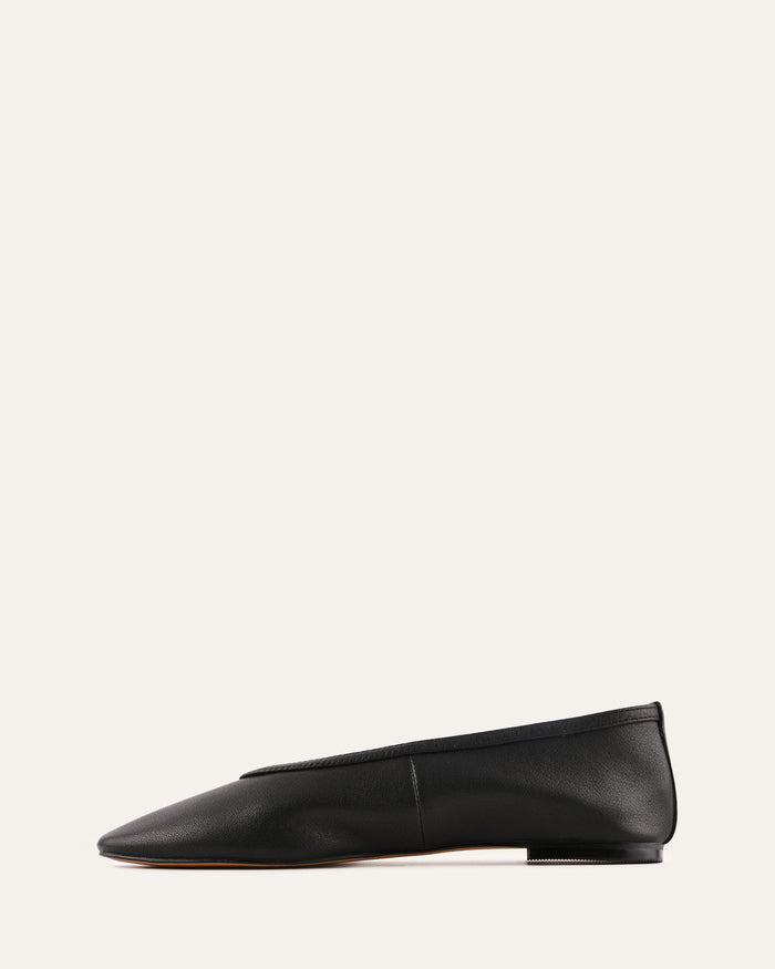 Black loafer shoe on a light beige background