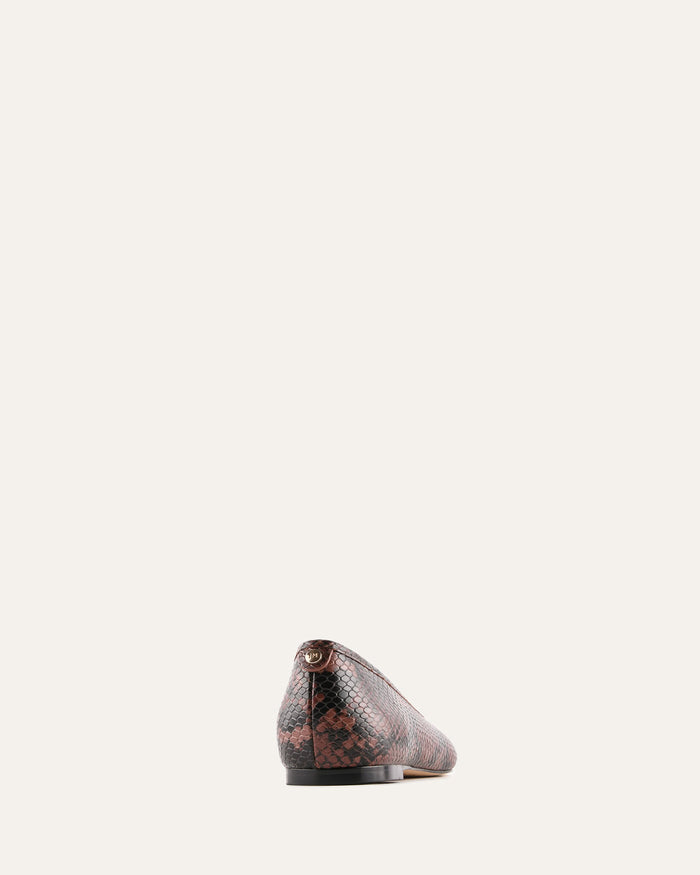 Snake patterned shoe on a light beige background