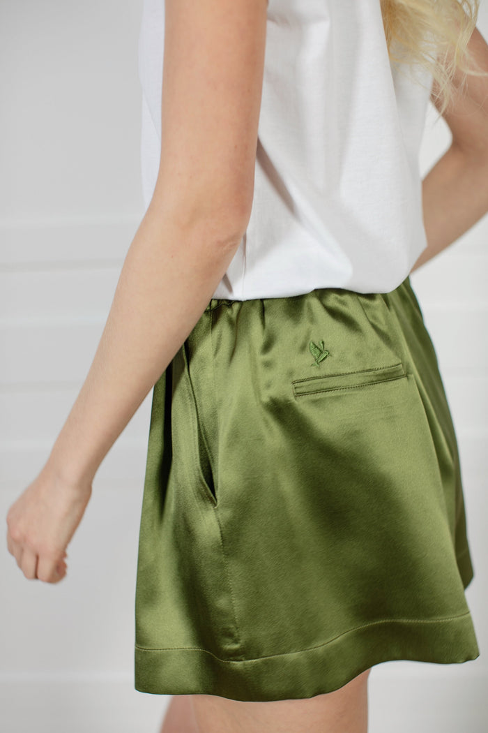 Signature Edit Green Lounge Shorts worn with a white top, front view.