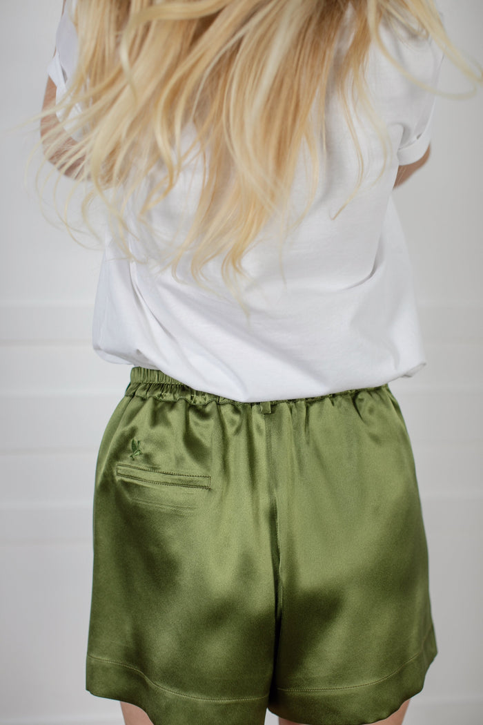 Signature Edit Green Lounge Shorts worn with a white top, back view.