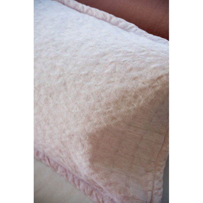 Close-up of a textured pink pillow on a neutral background
