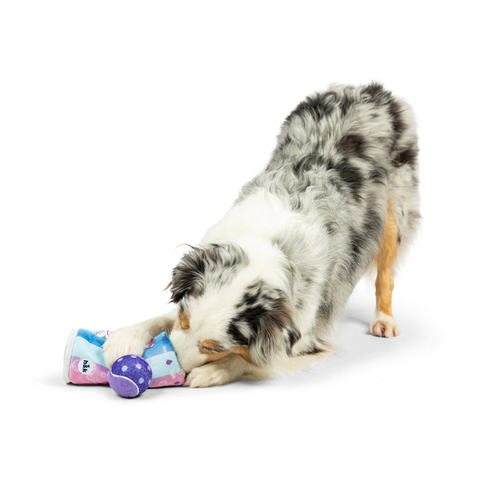 Dog with Squeak 'n Peek Puppi Pop Grape Dog Toy on a white background.
