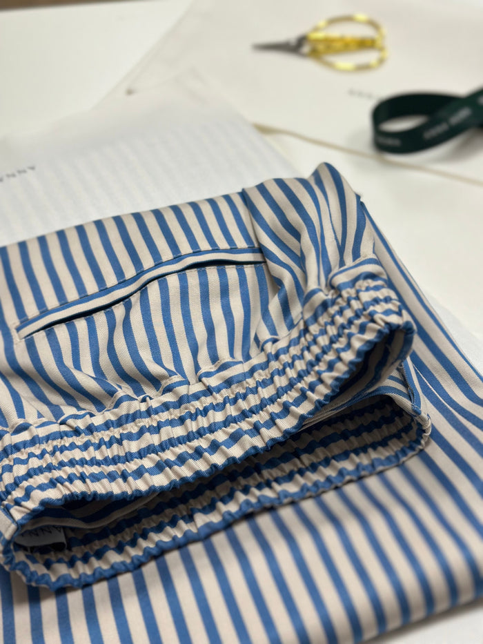 TENCEL™ Edit Blue Stripe Lounge Trousers waistband detail in an atelier setting.