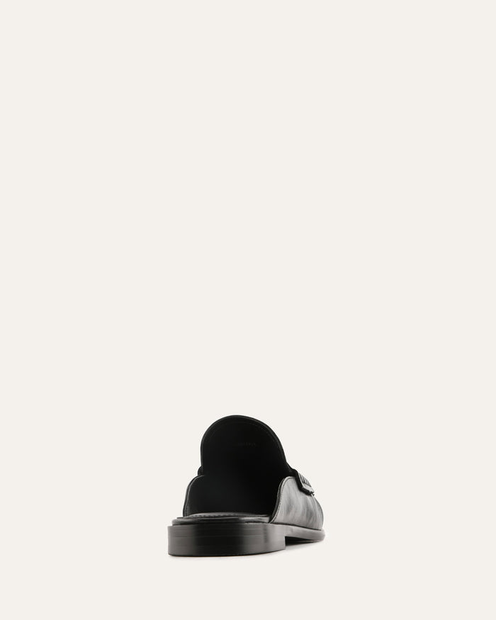Black slip-on sneaker on a light gray background