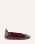 Burgundy leather flat shoe on a white background