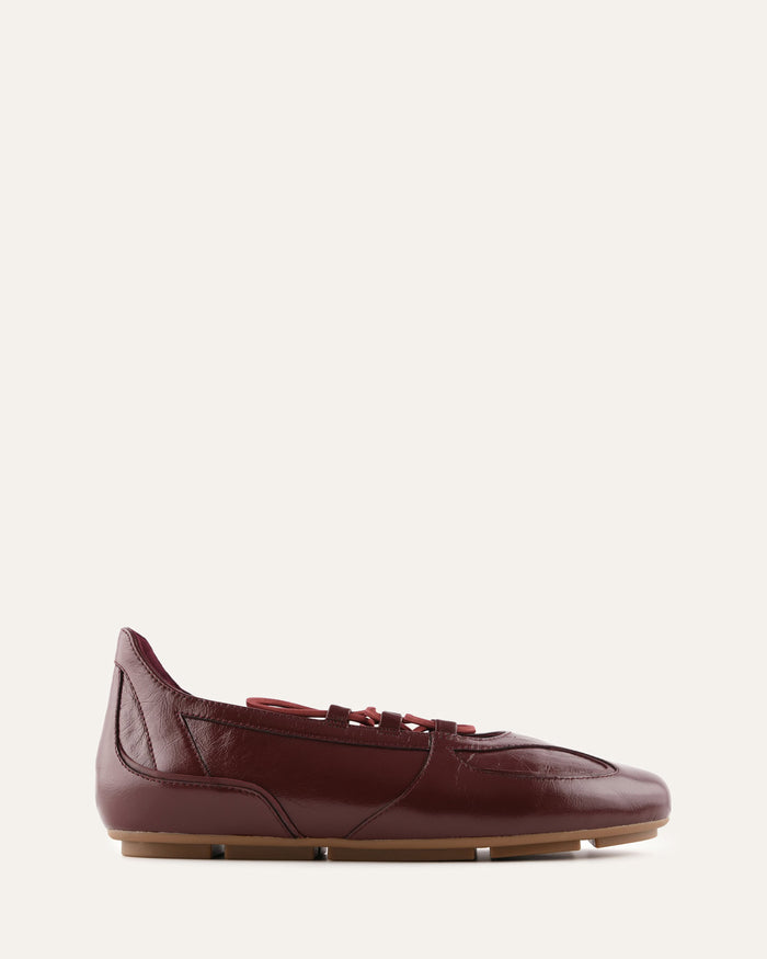 Burgundy leather flat shoe on a white background