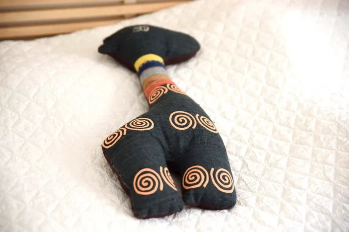 Soft spiral deer toy laying down on white blanket