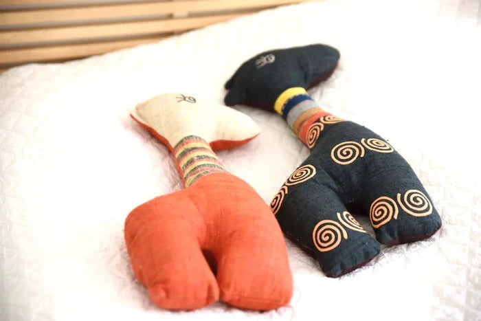 Handmade hemp deer toy with red legs and blue spiral body on couch