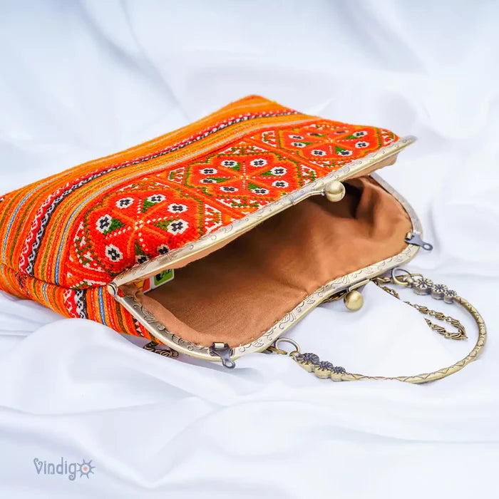 Öppen orange tygväska med beige innerfoder och metallkedja
