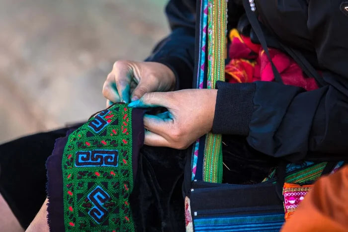 Artisan hand-stitching green tribal hemp clutch bag detail