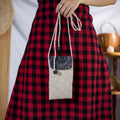 Natural hemp drawstring bucket bag with H’Mong patch, front view held by model
