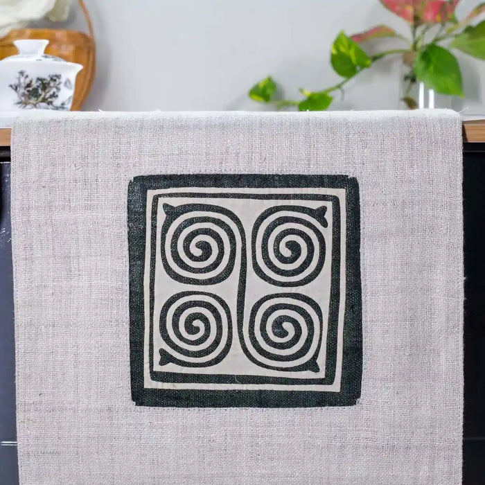 Vindigo beige hemp table runner close-up showing hand-stitched spiral H’mong motif