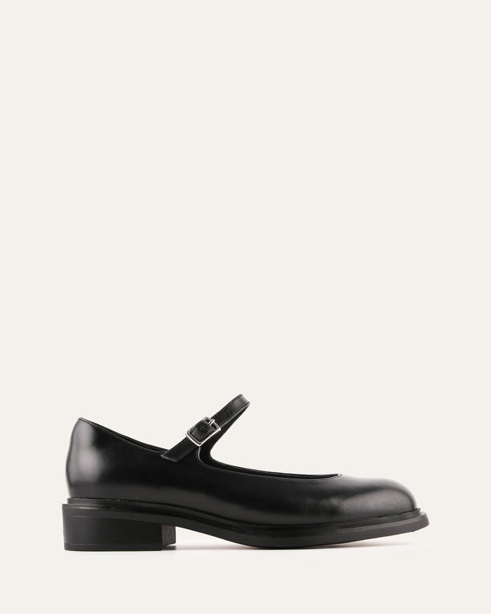 Black leather shoe with a strap on a white background