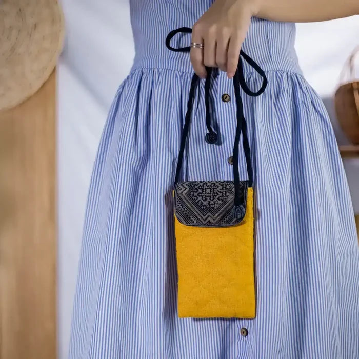 Model carrying eco-friendly yellow hemp phone crossbody bag with tribal patch