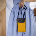 Model carrying eco-friendly yellow hemp phone crossbody bag with tribal patch