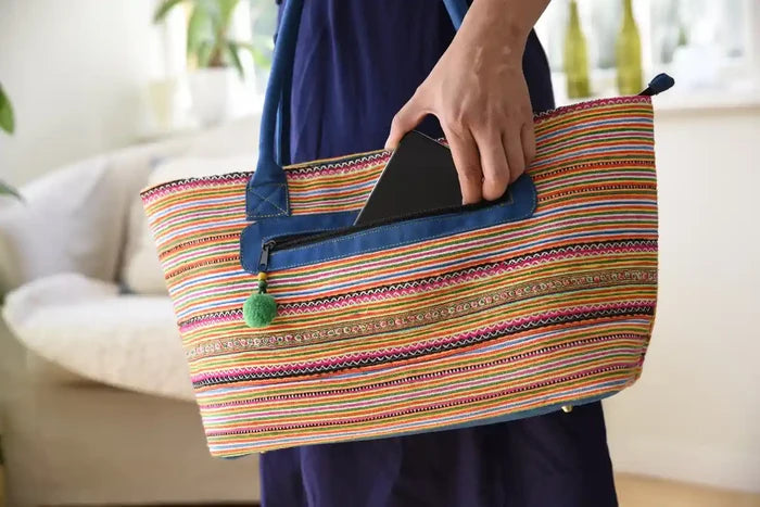Färgrik tygväska med blå handtag och ficka för surfplatta